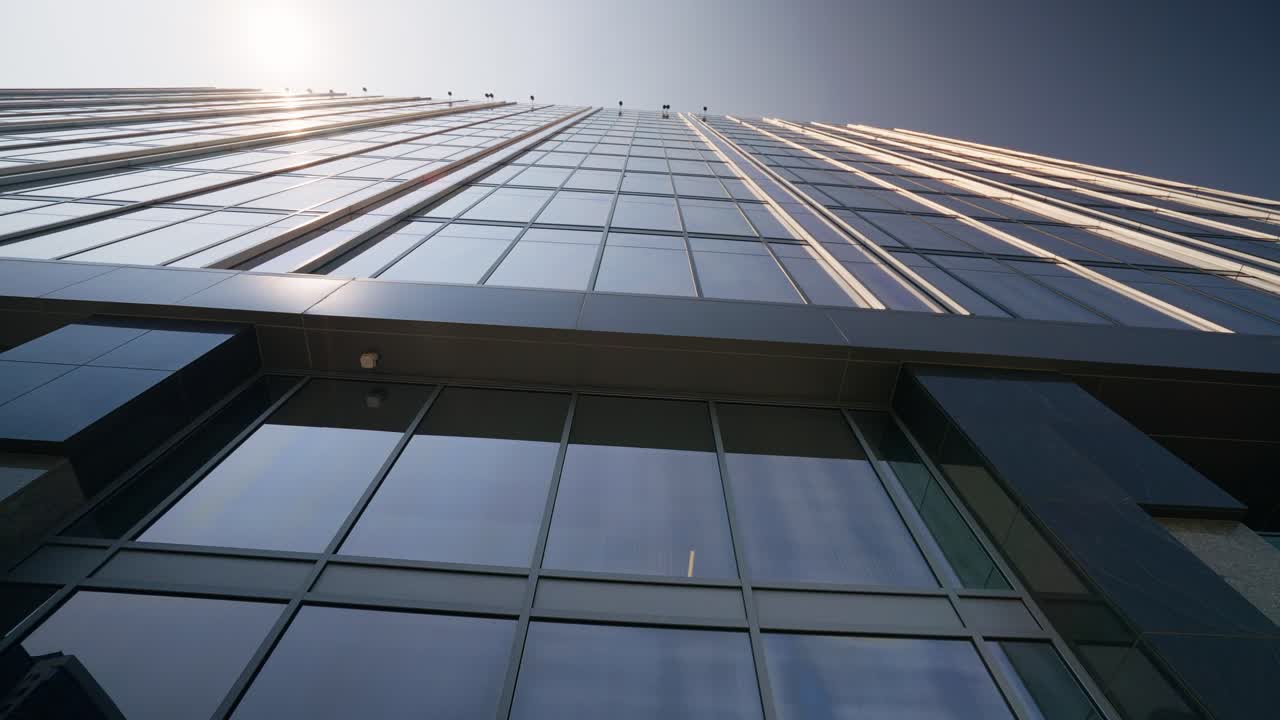 disparado hacia arriba desde el suelo a un altísimo rascacielos en un bullicioso centro de la ciudad, mostrando la impresionante altura arquitectónica y la atmósfera urbana