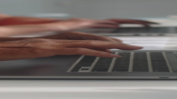 Mani di persone anziane che digitano su un laptop