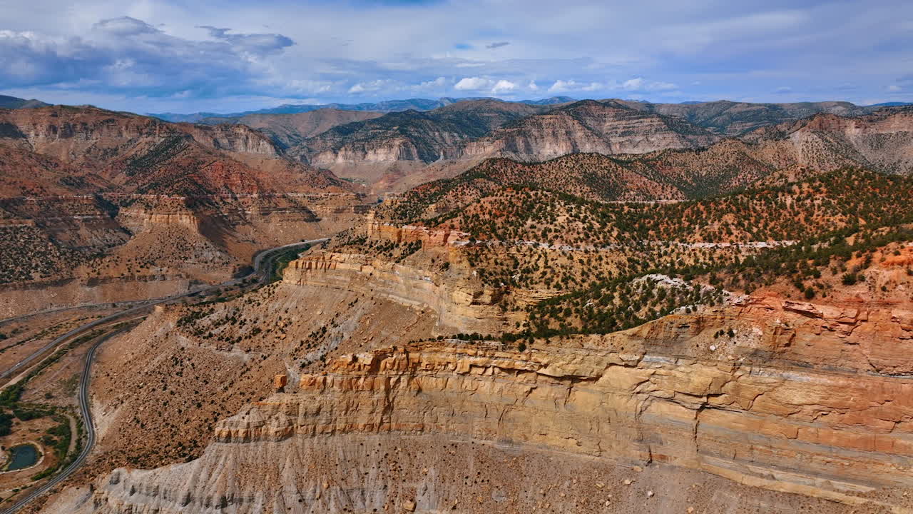 Ampia vista aerea da drone delle montagne di Price Canyon nello Utah con scogliere stratificate e strade tortuose sottostanti
