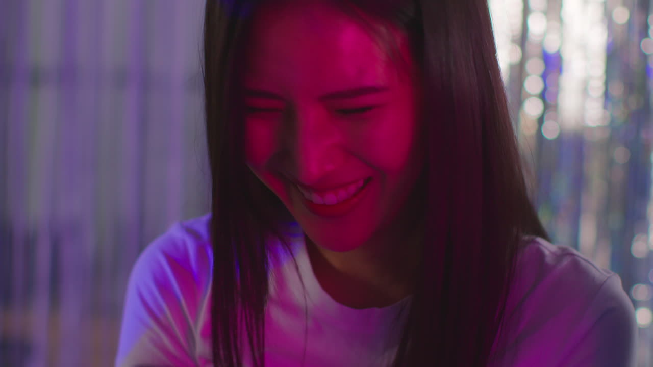 친구 들 의 그룹 이 나이트클럽 이나 파니페어 에서 사진 부스 에서 인쇄물 의 사진 을 찍고 있다