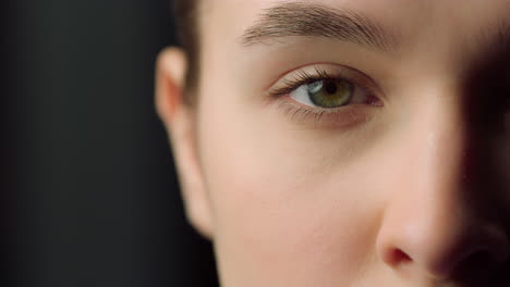 extremo primer plano de la mitad de la cara de la cara femenina seria en el interior. cerrar los ojos.