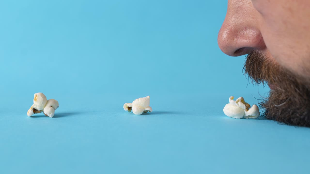 콘 어리를 먹는 수염이 있는 남자의 입