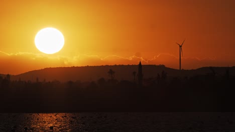 timelapse of sunset over mosque and wind turbine