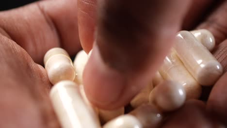 una mano sosteniendo un puñado de pastillas blancas