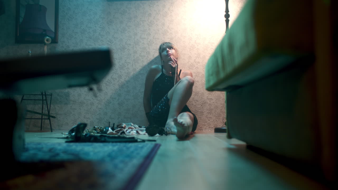Žena sedící na podlaze telefonující na retro telefonu.