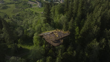 deserted ski jump surrounded with growing lush trees in bakuriani mountains, georgia