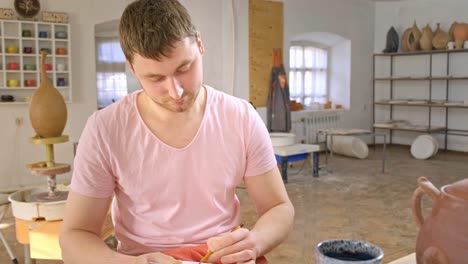 artistic focus: a craftsman dedicated to the creative process in a serene studio workshop, skillfully shaping pottery with precision and care