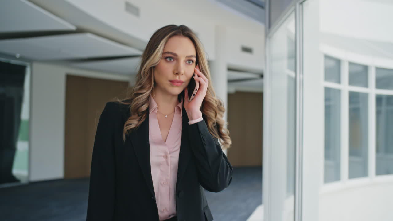Corporate professional calling smartphone walking modern office hallway closeup