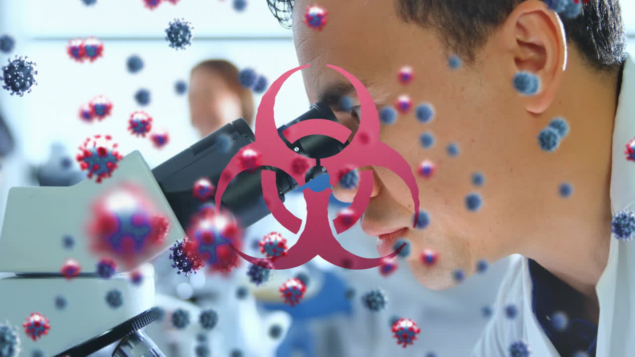 바이오 해저드 기호와 코로나19 세포를 마이크로스코프를 사용하여 남성 과학자에 대항합니다.