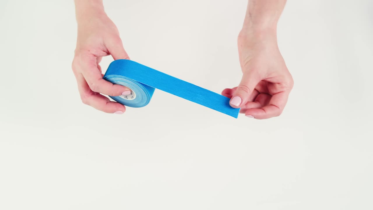 Kinesiology medical taping, doctor Physical therapist applying elastic surgical tape to patient body, treating injured knee young athlete.Post traumatic rehabilitation, sport physical therapy recovery