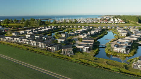 Panorama-Von-Stilvollen-Bungalow-Ferienhäusern-Mit-Grünen-Feldern-Im-Vordergrund-In-Der-Nähe-Von-Kamperland,-Zeeland,-Niederlande