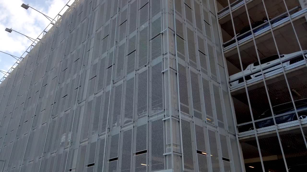 Panning shot of multiple storey airport car park building from the outside