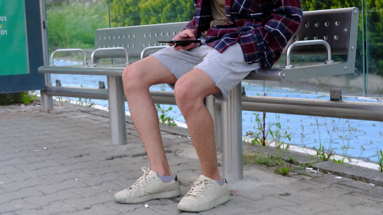 젊은 남자 전화에 앉아