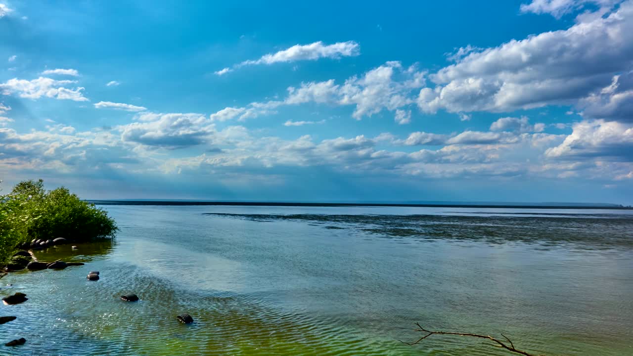 Time lapse: Video landscape - sky, clouds, large lake, horizon. The clouds float above the lake. The weather is changing.