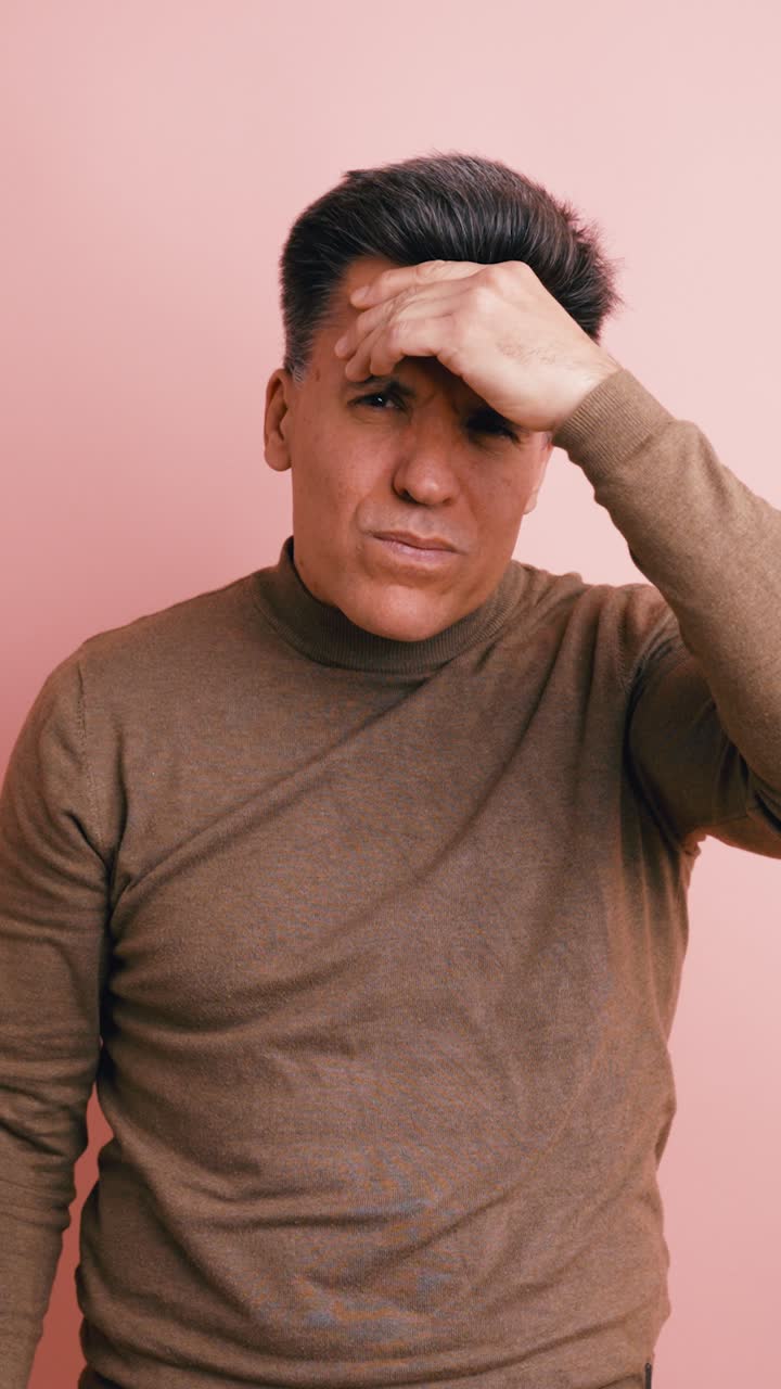 Man Suffering from Headache or Stress on Pink Background