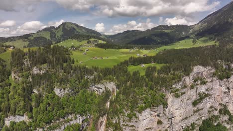 aerial view captures the picturesque mountainous region of amden, glarus, switzerland, revealing a harmonious blend of lush green valleys, dense forests, and towering peaks