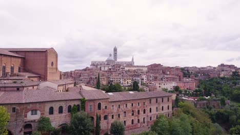 Drone-approaching-the-historical-city-center-medieval-town-of-Siena,-Tuscany-,-Italy