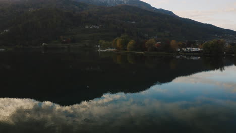 Un-Dron-Sigue-A-Un-Pájaro-Volando-Sobre-El-Agua-En-El-Lago-Caldonazzo