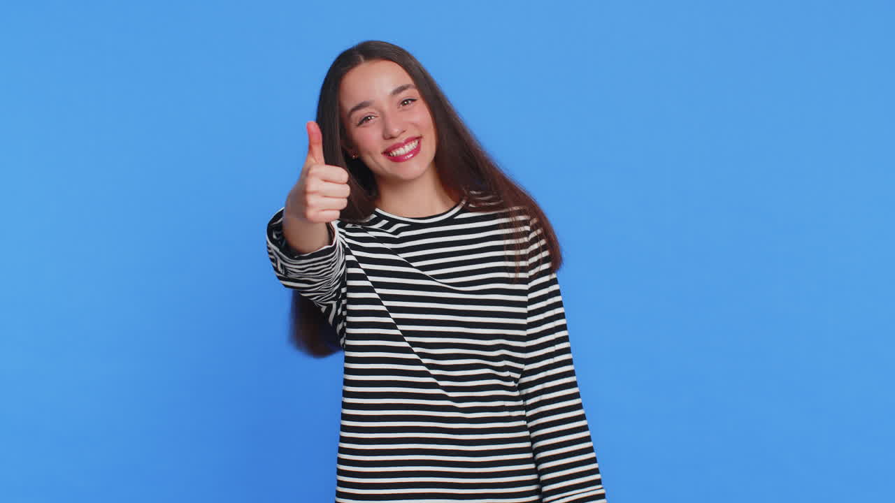 la mujer caucásica levanta el pulgar, está de acuerdo, da una respuesta positiva, recomienda el anuncio, le gusta, buena idea.