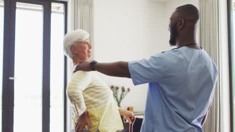 video of happy african american male doctor supporting caucasian senior woman