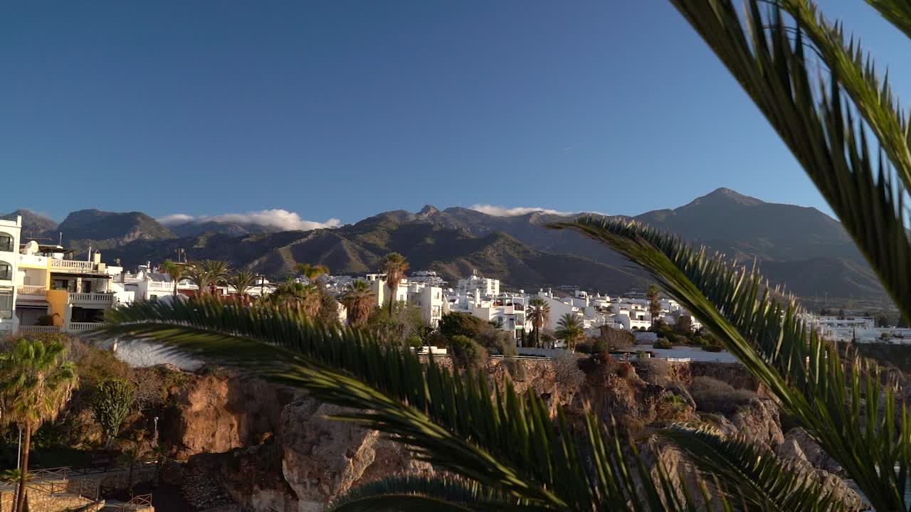 villas encaladas vistas entre hojas de palmera