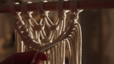 Close-up view of hands macrame knotting