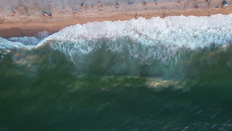 Vista-Relajante-De-Las-Olas-Verdes-Del-Océano-Rompiendo-En-Una-Playa-Mexicana-En-Puerto-Vallarta-Al-Atardecer,-Vista-Aérea-De-Arriba-Hacia-Abajo