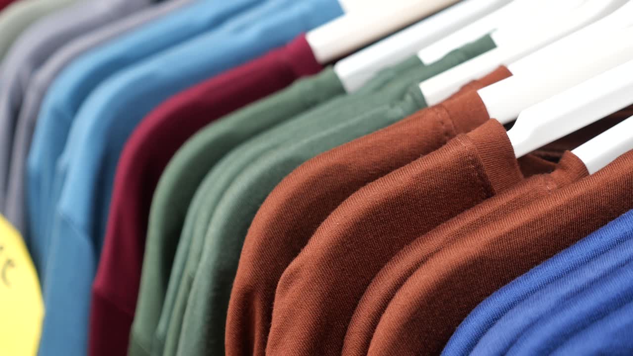 Person selecting t-shirts from a rack