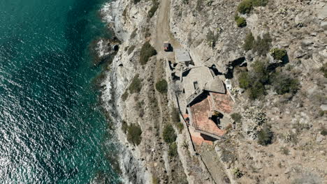 Cap-De-Creus-in-Catalonia,-Spain,-aerial-flying-above-house-by-coast-cliff