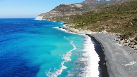 Drone-flies-over-Nonza-beach-with-black-sand-in-Corsica