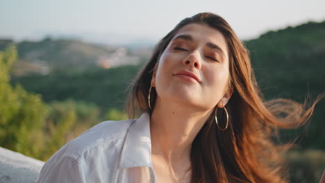dama feliz disfrutando del sol de verano balcón primer plano. mujer tierna mirando cámara