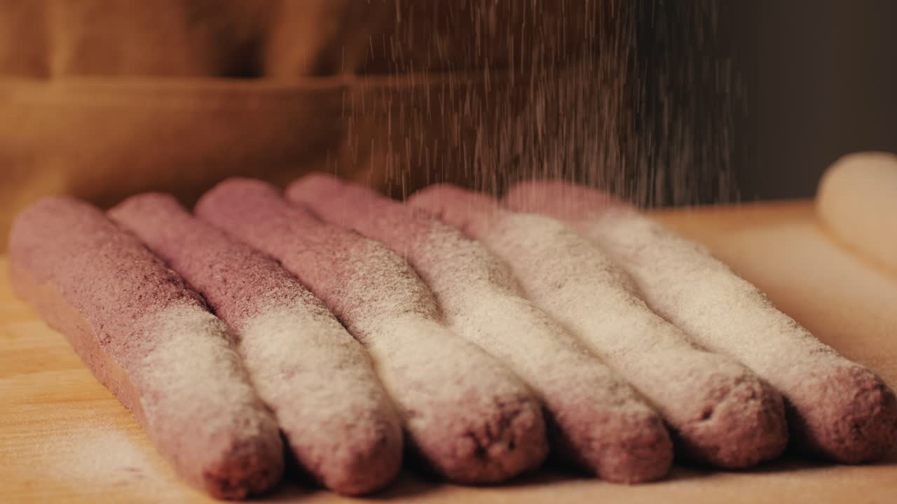 Bakery chef applying flour on dough, young man kneading dough, making bread using traditional recipe. Artisan bread is making by skill bakers using natural and high-quality ingredients. Food with health and flavour benefits.