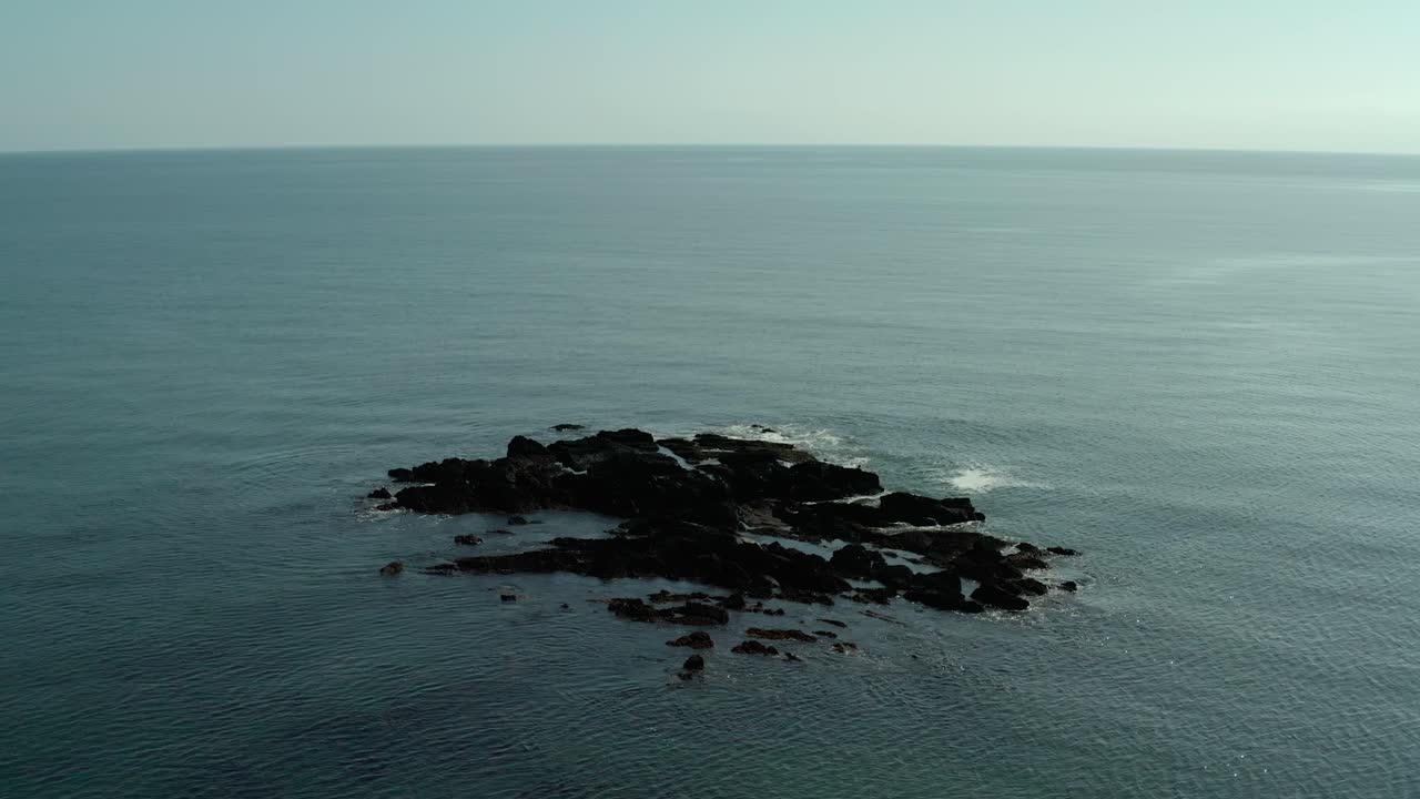 잔잔한 날에 바다 물에 바위의 공중 광각 궤도