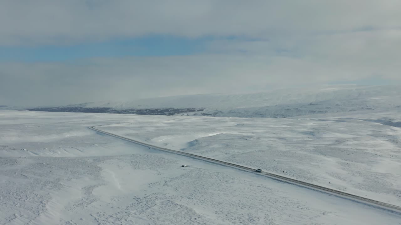 съемка с беспилотника 4k движения автомобиля по заснеженному ландшафту в исландии