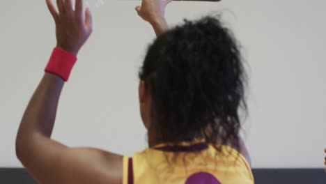 diverse female basketball team training with male coach in indoor court, in slow motion