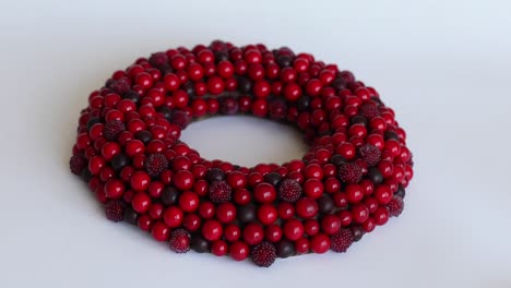 corona de navidad de bayas rojas en un fondo blanco aislado