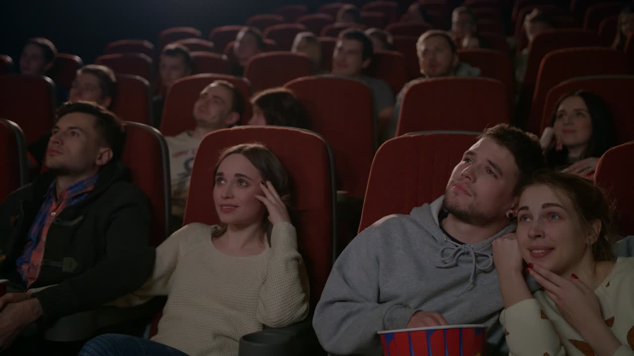 parejas de amor viendo una película en el cine. pareja joven abrazándose en el cine