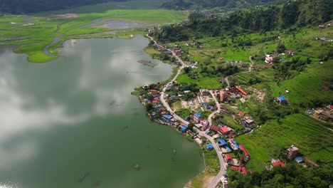 stunning aerial view of a village on phewa lakeside, drone flying down in pokhara, nepal