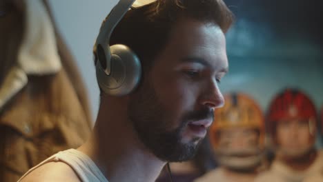 close profile shot on face of focused man wearing headphones working on computer