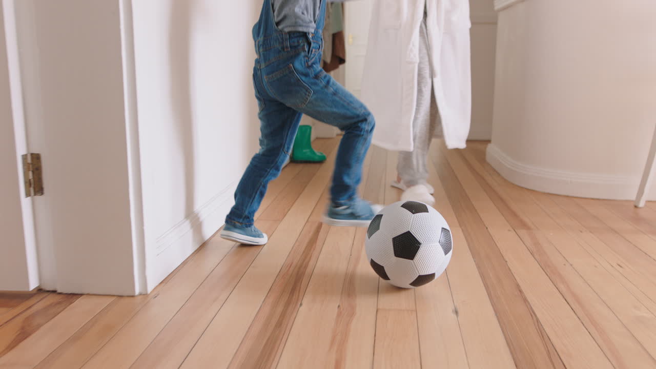 madre y hijo felices jugando al fútbol en casa niño pequeño jugando con mamá disfrutando de un divertido fin de semana juntos 4k footage