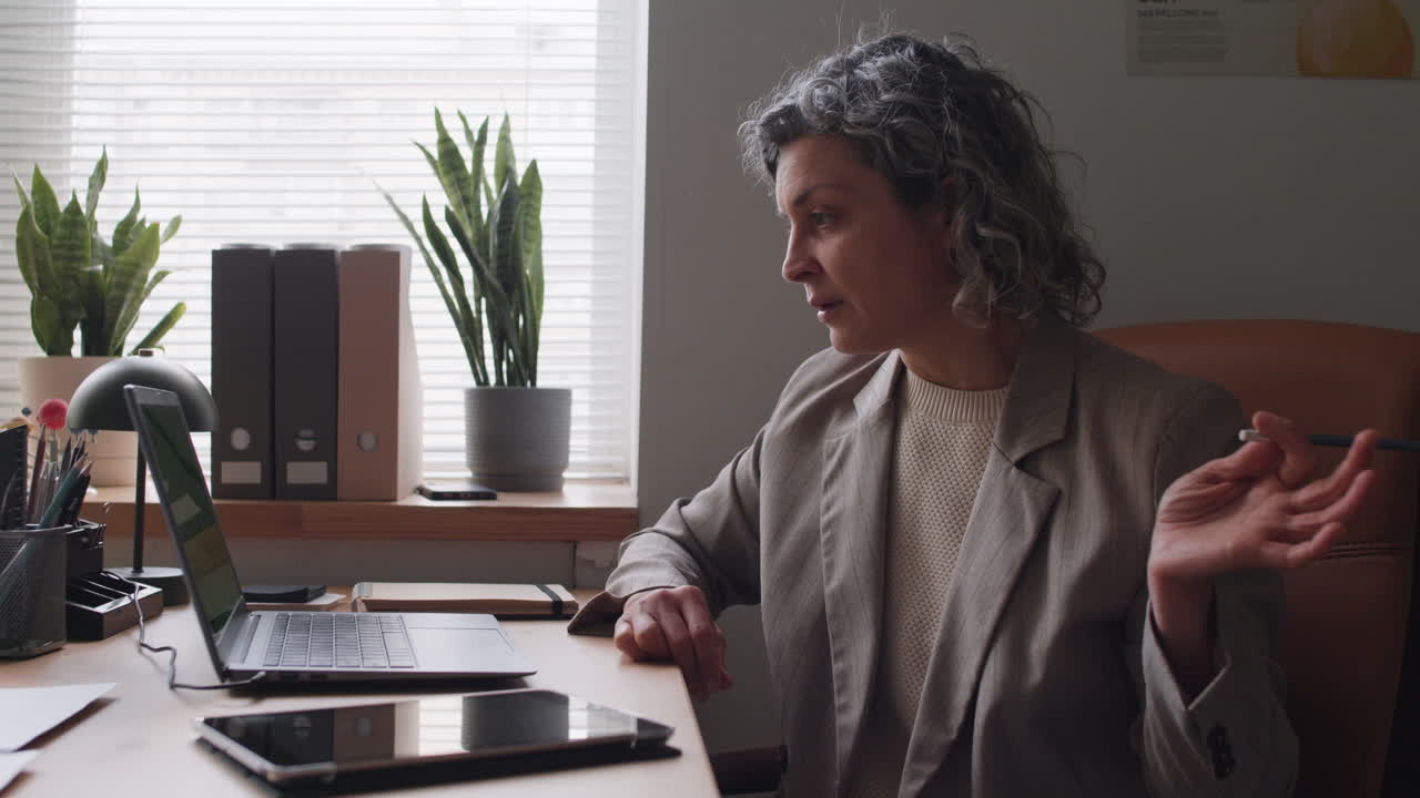 Donna in videochiamata in un ufficio domestico