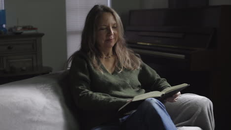 Mujer-De-30-Años-Leyendo-Un-Libro-Mientras-Se-Relaja-En-La-Sala-De-Estar-Durante-Su-Tiempo-Libre