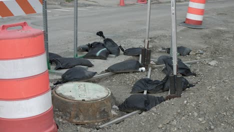 Schwarze-Sandsäcke-Waren-Früher-Ein-Gewicht-Auf-Metallpfosten-Beim-Straßenbau