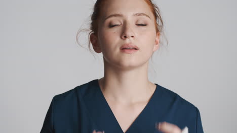 redheaded doctor in front of camera on gray background.