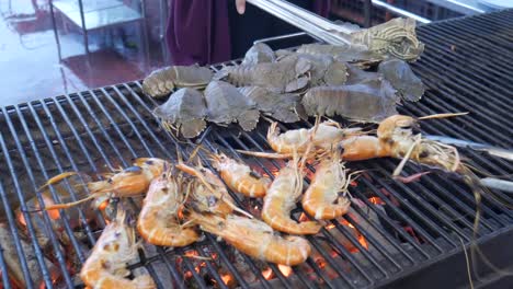 grill cooking slipper lobster and river prawn on hot charcoal in thailand seafood restaurant