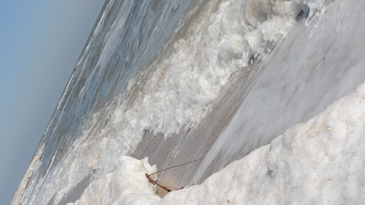 Mare d'inverno. Sabbia e ghiaccio su una spiaggia