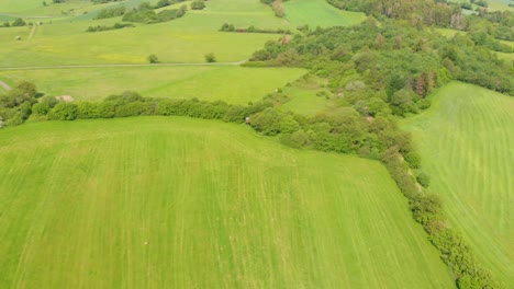 flying over rolling hills with fields in a rural countryside