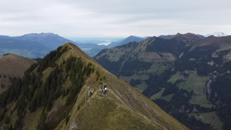 flying over the cross on the peak of a swiss mountain with the alpes in the background