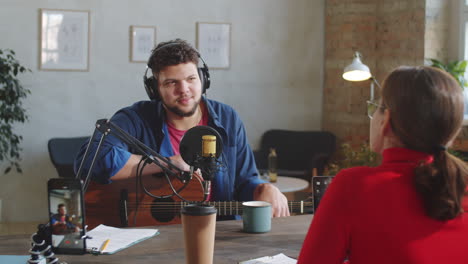 cheerful male musician giving podcast interview in studio