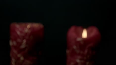 detailed view of a burning red candle with intricate decorative designs against a dark background, creating a warm and intimate atmosphere. perfect for relaxation or meditation visuals